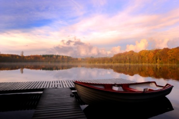 Fishing boat docked on a quiet lake