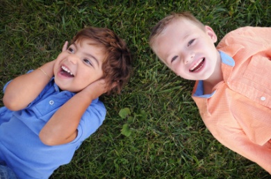 Boys laying and laughing on the grass