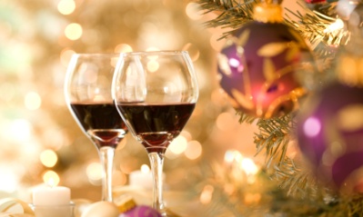 Two glass of red wine beside a Christmas tree