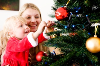 Mom and daughter decorate a Christmas tree