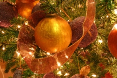 A  gold ornament on a Christmas tree