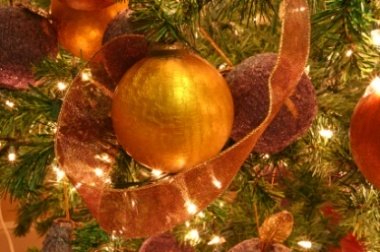 A gold ornament on a Christmas tree A gold ornament on a Christmas tree